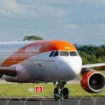 Avion easyJet orange et blanc sur la piste, pour un vol payé avec des chèques vacances