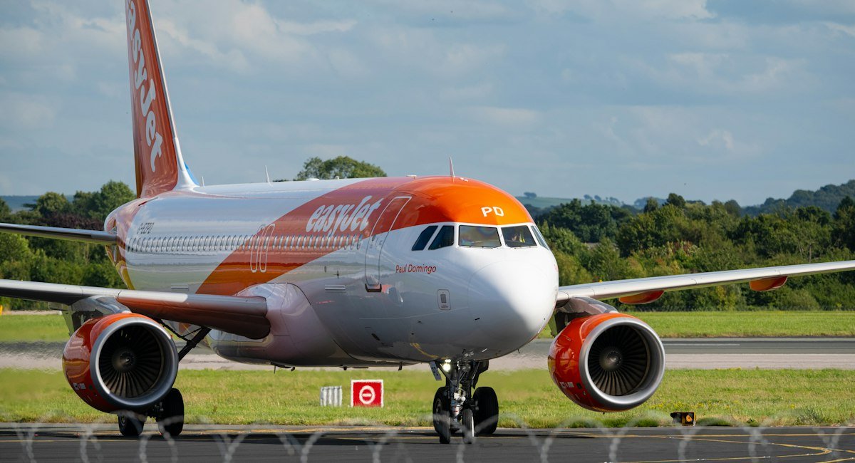 Avion easyJet orange et blanc sur la piste, pour un vol payé avec des chèques vacances